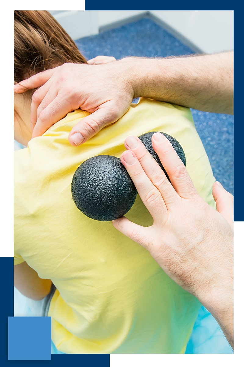 physical therapist using roller on patient's spine