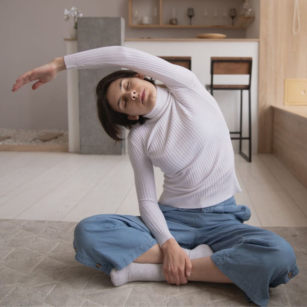 stretching back to side, sitting on floor — yoga