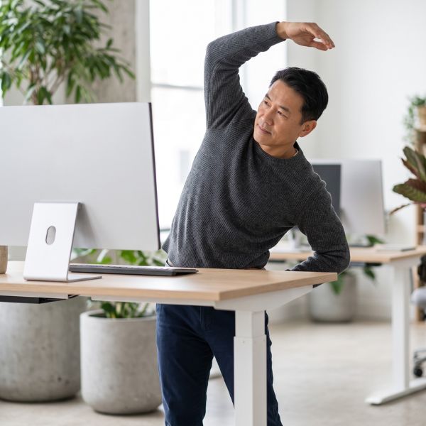 man stretching at computer
